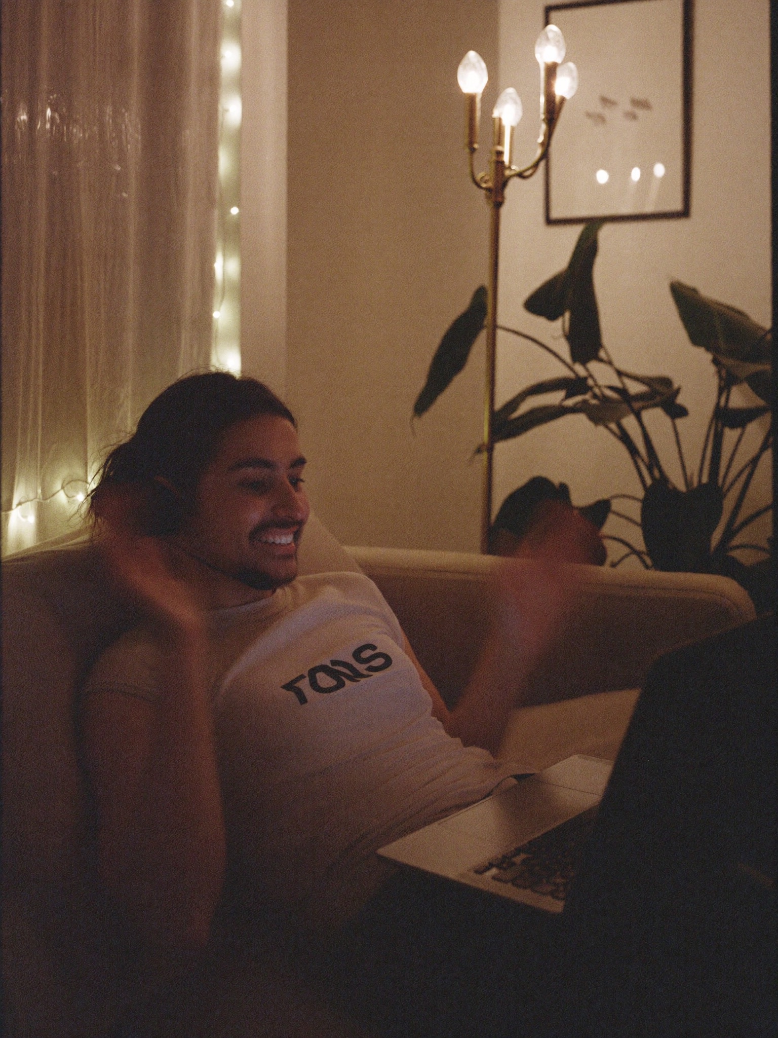 A man laughing during a late-night video call at home