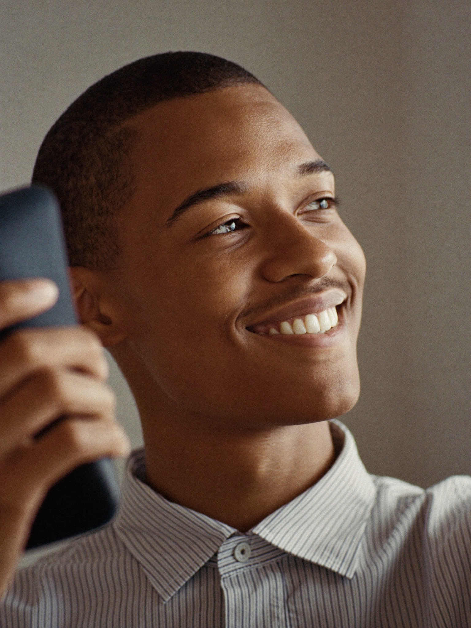 A smiling man holding his phone up for a live face scan